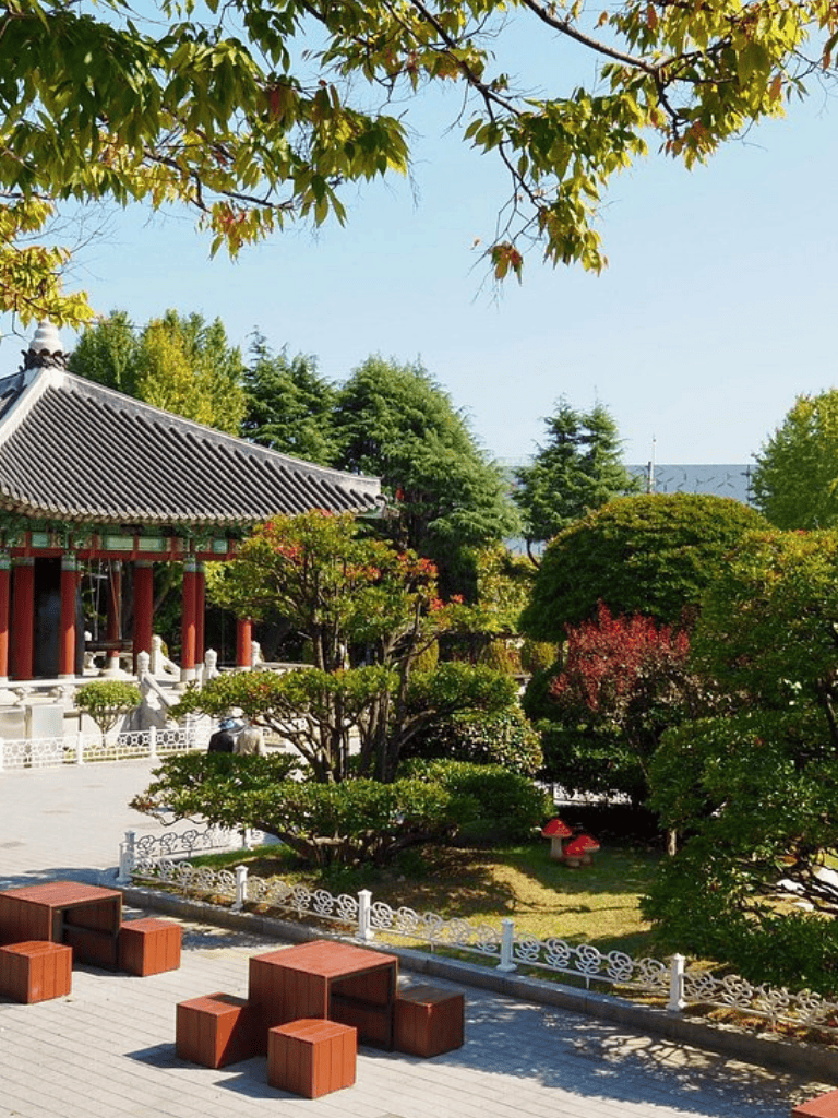 Serene garden with traditional Asian pavilion, lush trees, and outdoor seating area for peaceful relaxation.