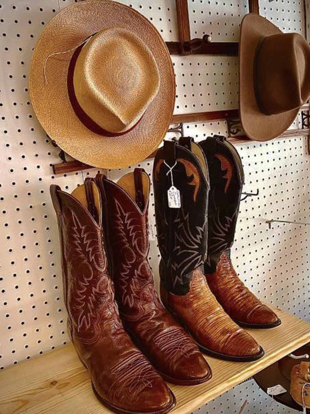 Vintage cowboy boots and straw hats at a western shop for outdoor adventures.