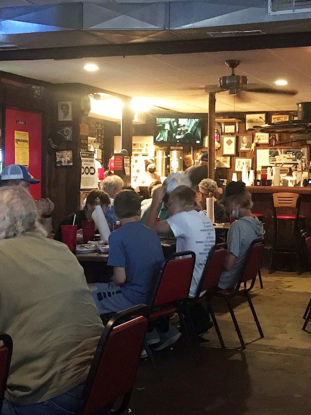 Crowded restaurant interior filled with customers dining and socializing.
