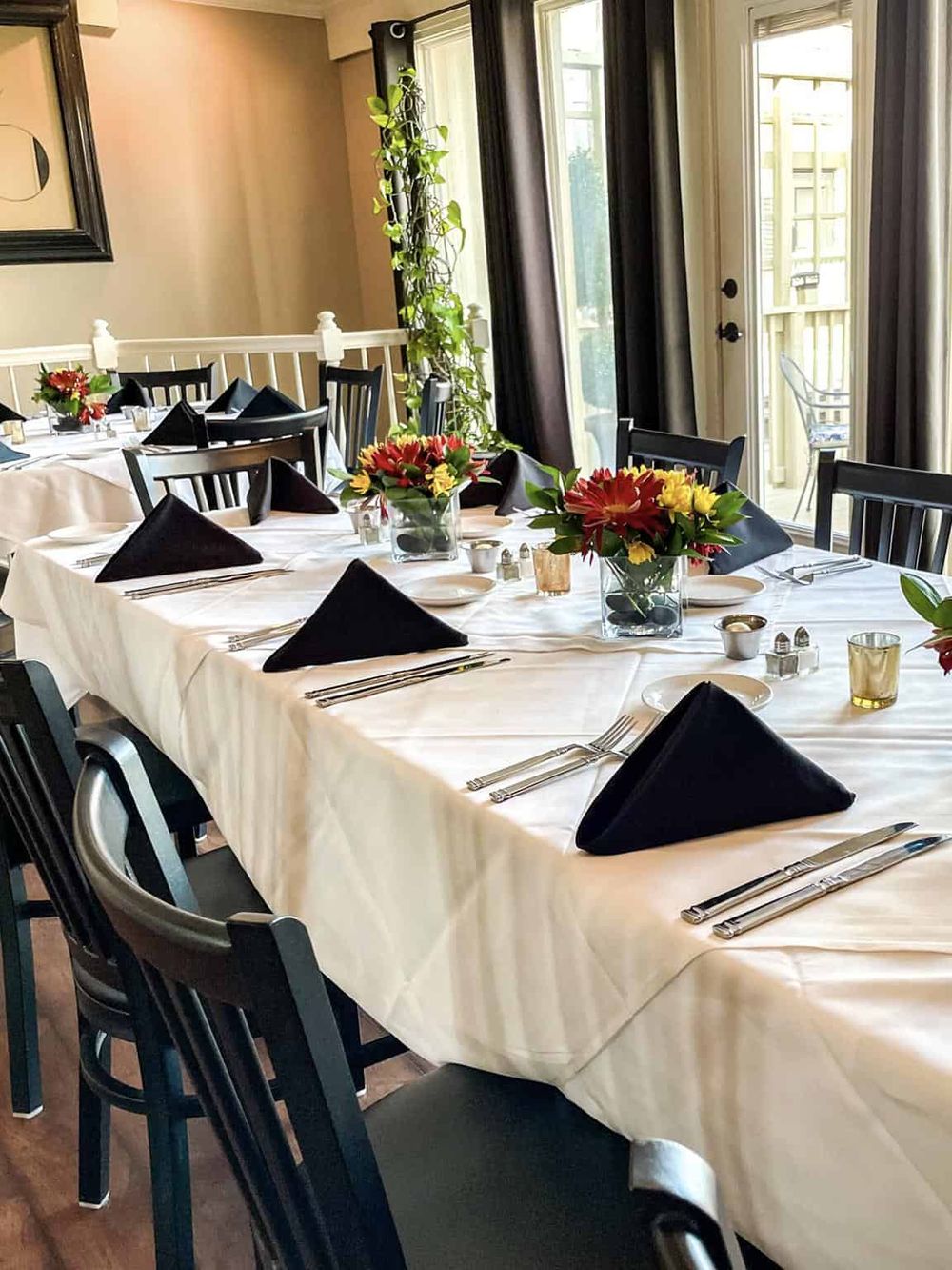 Elegant restaurant setup with floral centerpieces and neatly arranged tableware for special dining events.