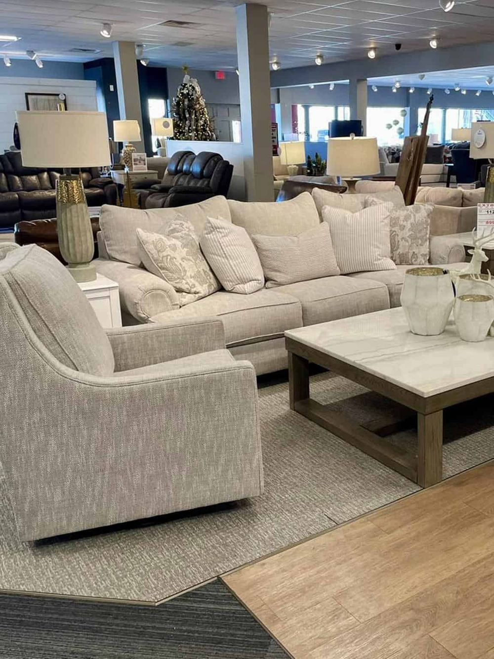 Comfy beige sofas and elegant lamps in a cozy furniture showroom displaying living room decor.