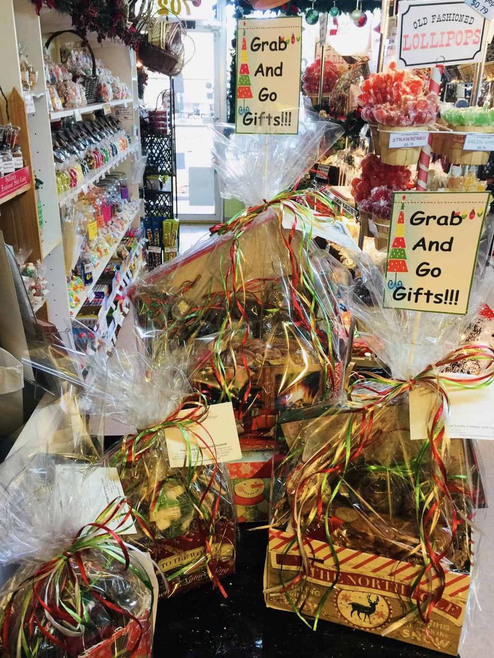 Colorful holiday gift baskets wrapped in clear cellophane with festive ribbons, perfect for Christmas gifts.