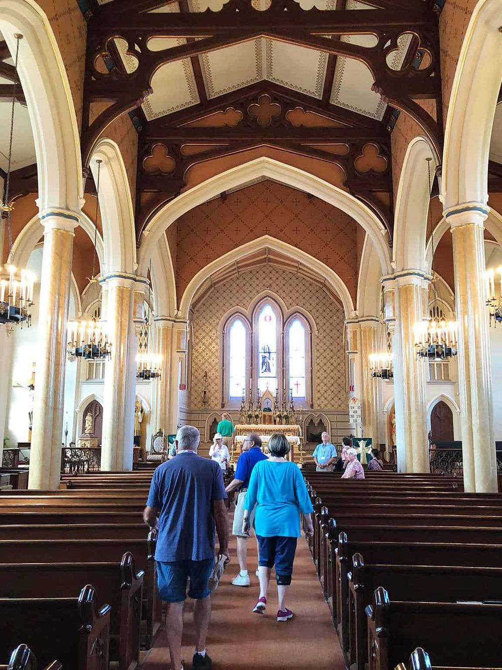Intricate Gothic church interior with stained glass windows and elegant wooden pews, inspiring spiritual journeys.