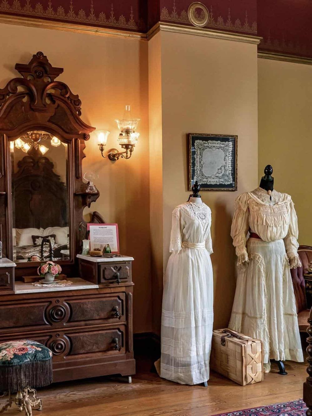 Vintage Victorian bedroom decor with antique mirror and costumes for historical reenacting or events.