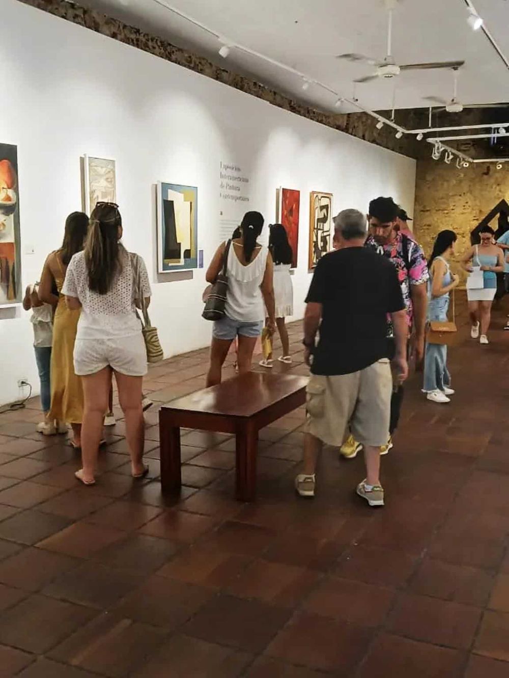 Colorful art gallery with visitors viewing modern artwork in a spacious museum setting.