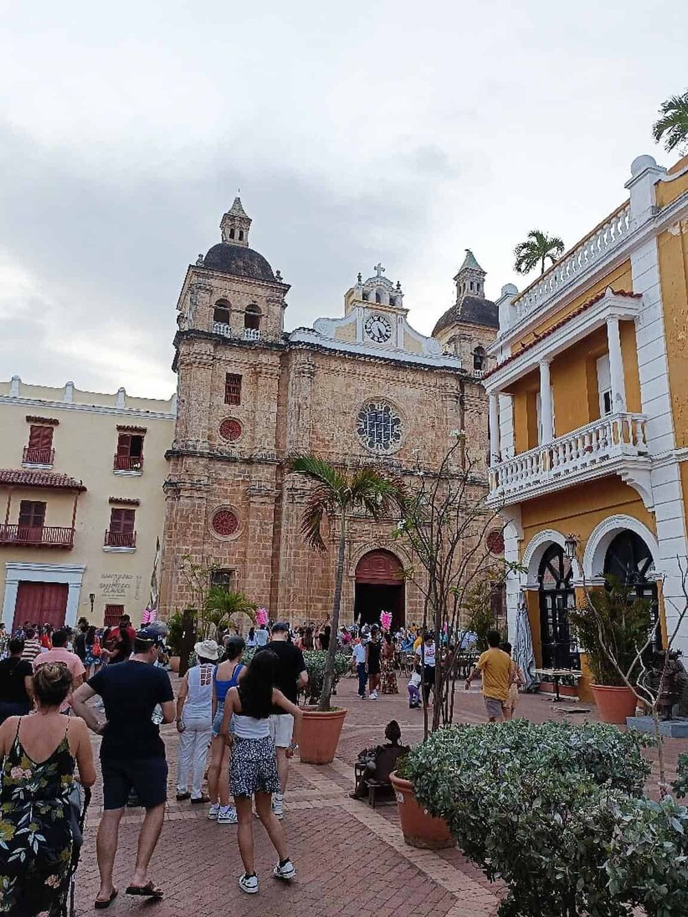Colorful church with crowd, historic architecture, and lively atmosphere in a popular tourist destination.