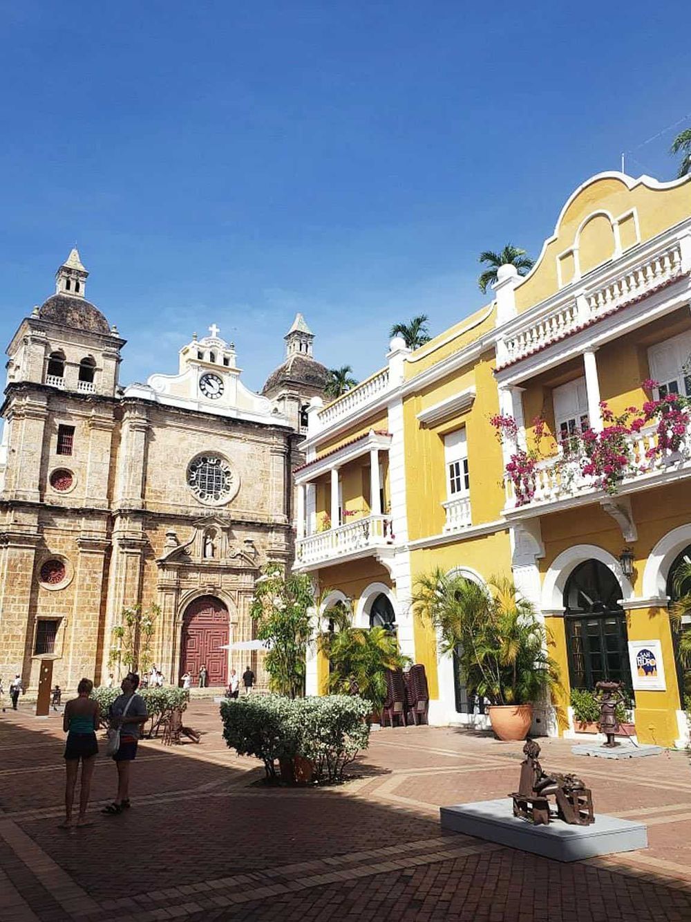 Colorful historic church and yellow building in the scenic town square, perfect for travel and exploration.