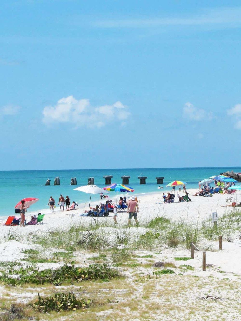 Vibrant beach scene with umbrellas, sunbathers, and ocean waves, perfect for vacation planning and seaside exploration.