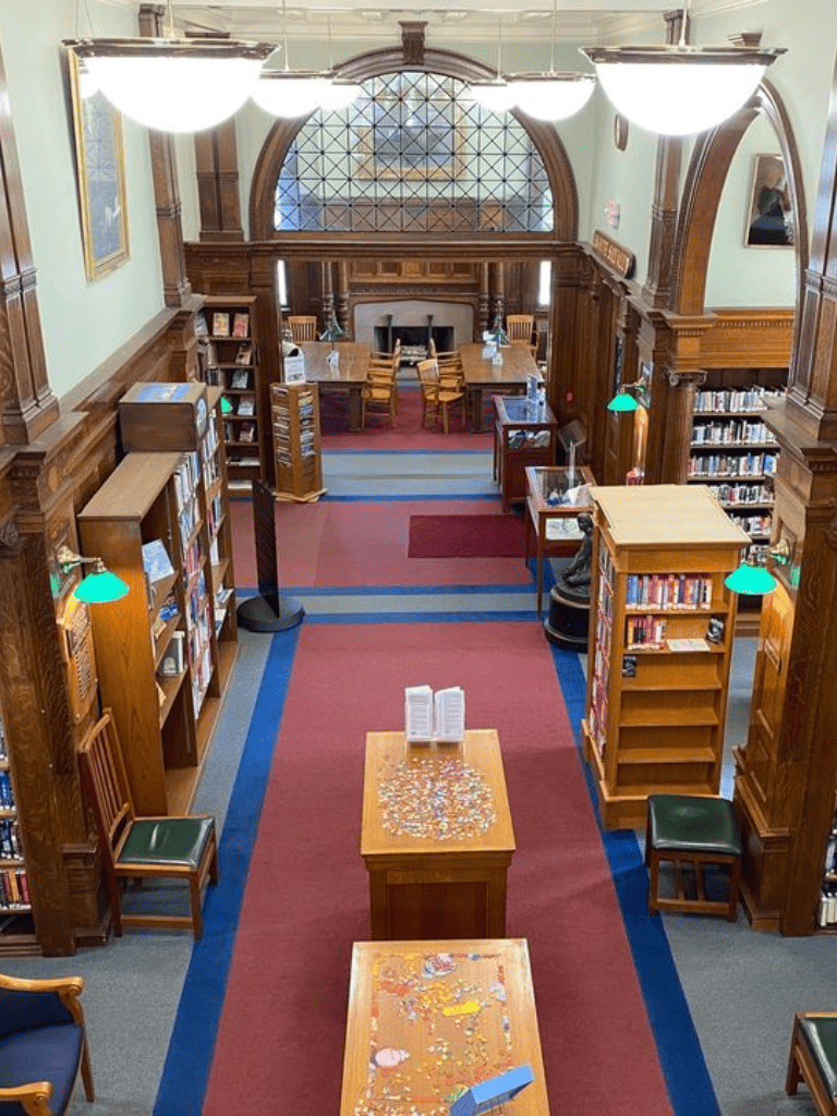Quiet library reading space with wooden bookshelves, tables, and vintage decor, ideal for study and research.