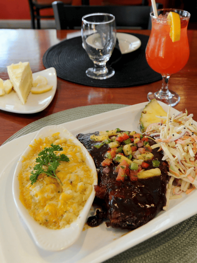 Savory grilled steak with mashed potatoes and coleslaw, complemented by drinks, at QuestForDirections restaurant.