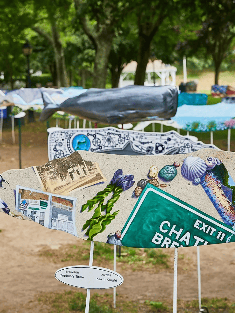 Colorful ocean and beach themed artwork with seashells, seas stars, and an Exit 11 sign at QuestForDirections event.