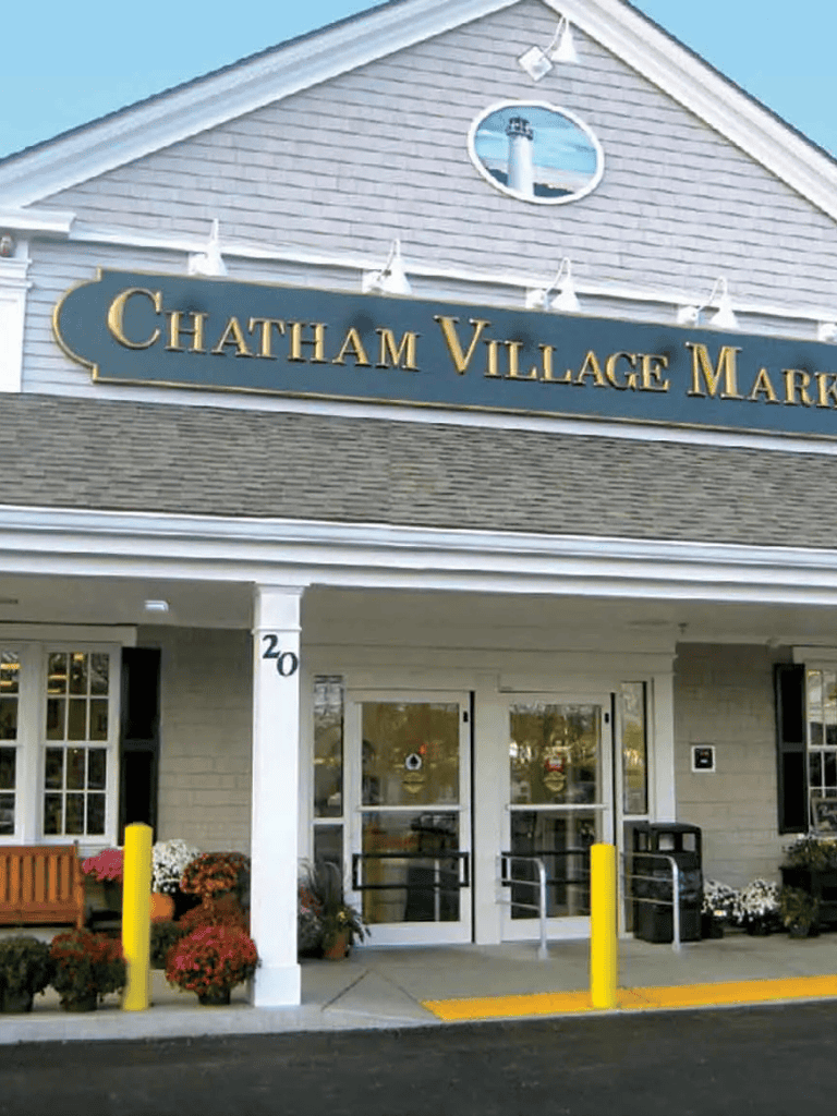 Chatham Village Market entrance with welcoming storefront and fall flowers, emphasizing local shopping and community.