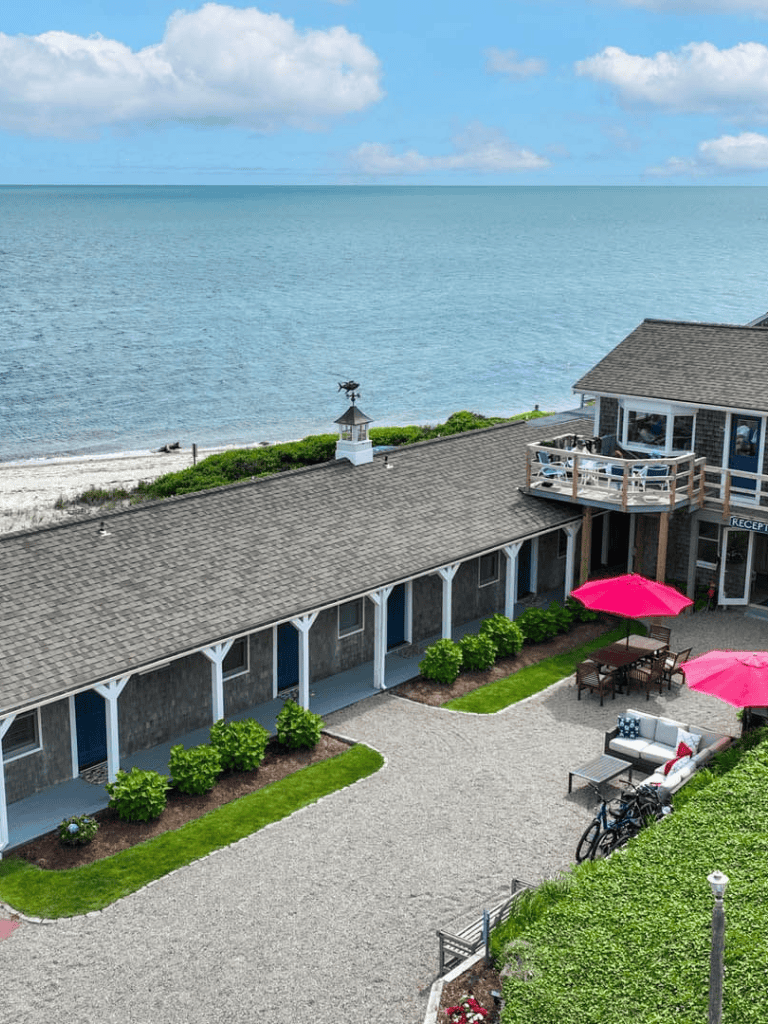 Coastal beachfront building with outdoor patio and umbrellas, scenic ocean view, and relaxing seaside ambiance.