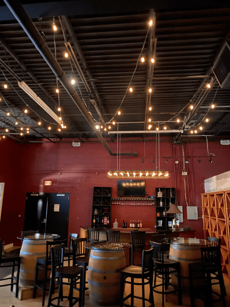 Cozy wine bar with wine barrels, warm lighting, and a modern industrial design atmosphere.