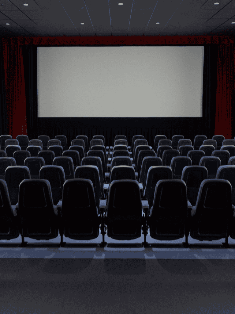 Empty theater or conference room with rows of chairs facing a large screen for presentations or screenings.