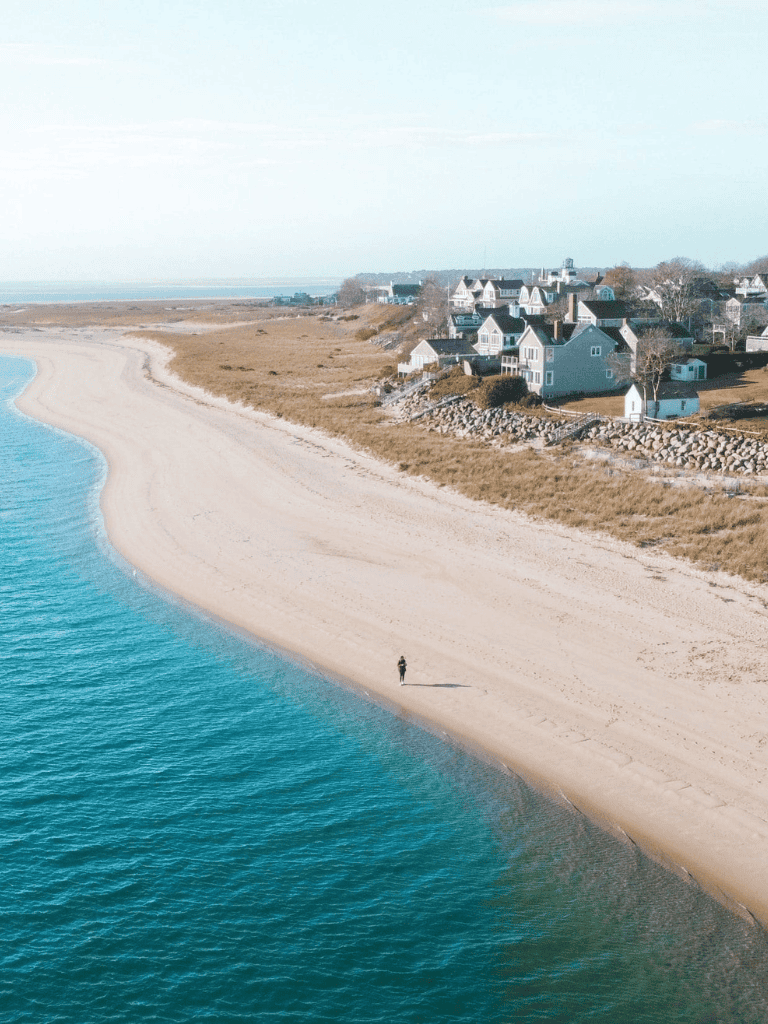 Serene coastal beach with seaside houses and clear blue waters, perfect for scenic oceanfront living.