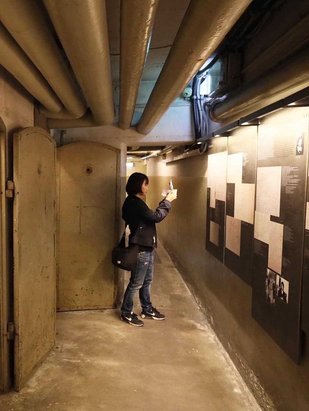 A woman reading historical exhibit display at Quest For Directions museum, underground exhibit on historical navigation tools.