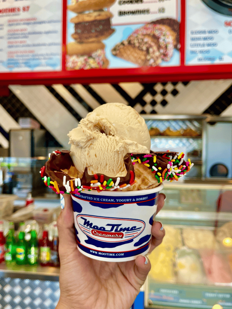 Creamy vanilla ice cream with chocolate-dipped waffle cone, colorful sprinkles, and Moo Time Cherryberry cup.