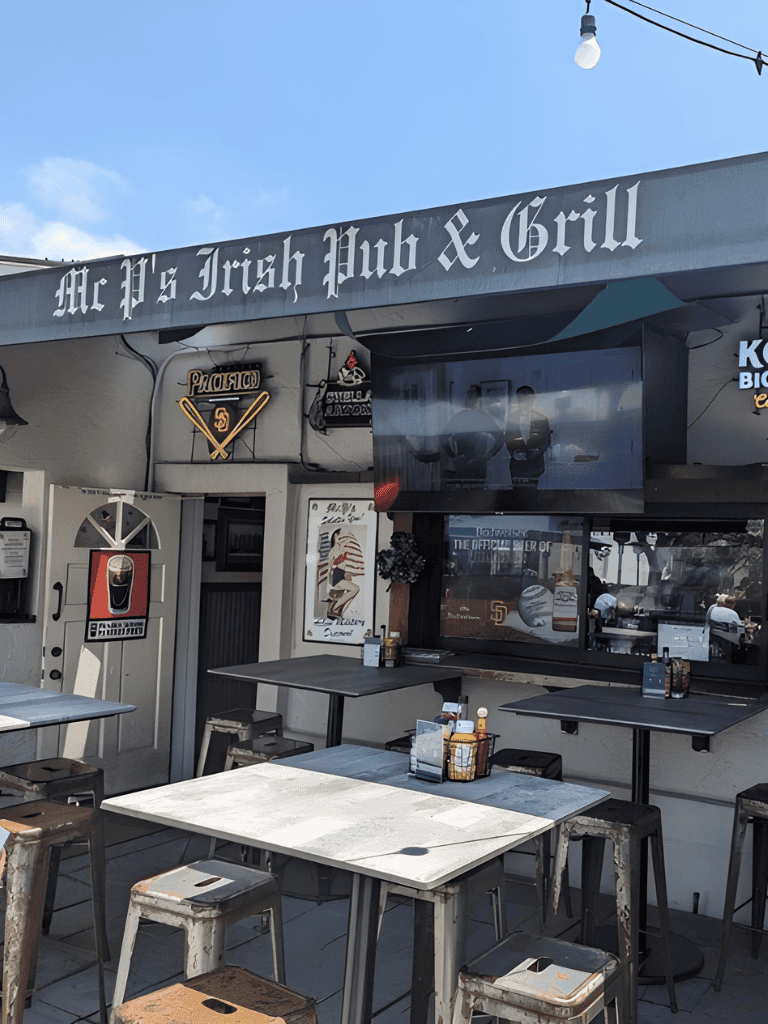 Bright outdoor seating area at Irish pub and grill with vintage decor and TV screens, perfect for sports and casual dining.