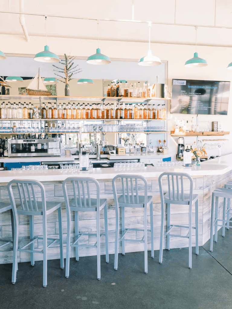 Bright modern cafe with bar seating, stylish decor, and a beverage station for guests.