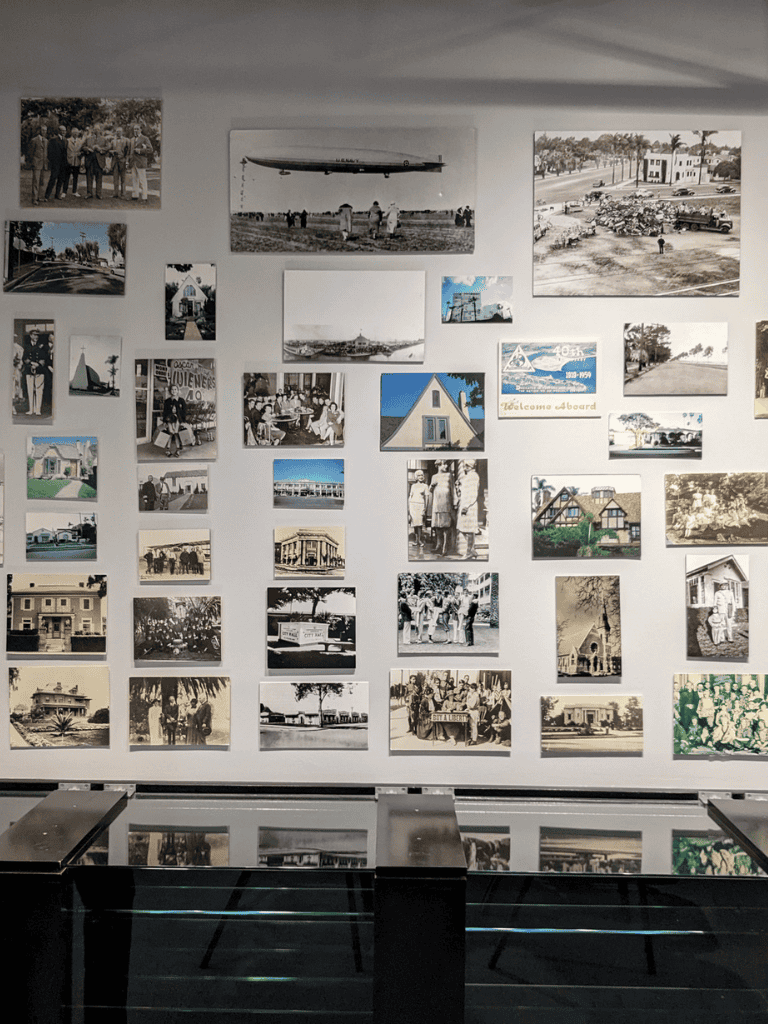 Vintage black and white and color photos displayed on a wall, showcasing historical scenes and community life.