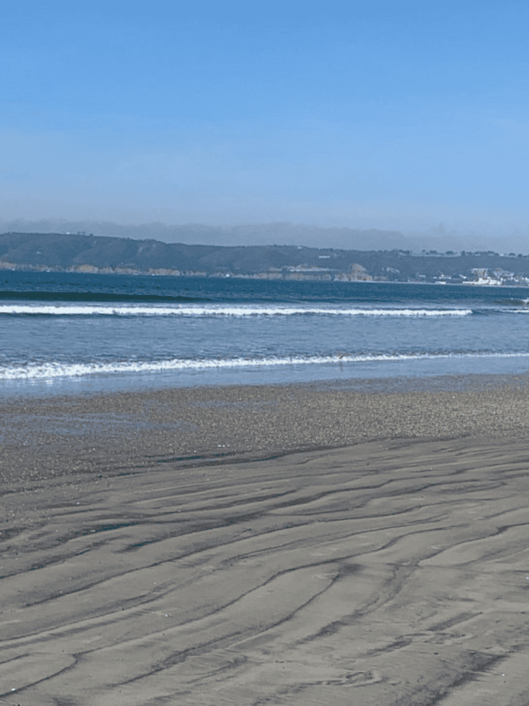 Serene beach with gentle waves and sandy shoreline, perfect for relaxing and enjoying coastal scenery.