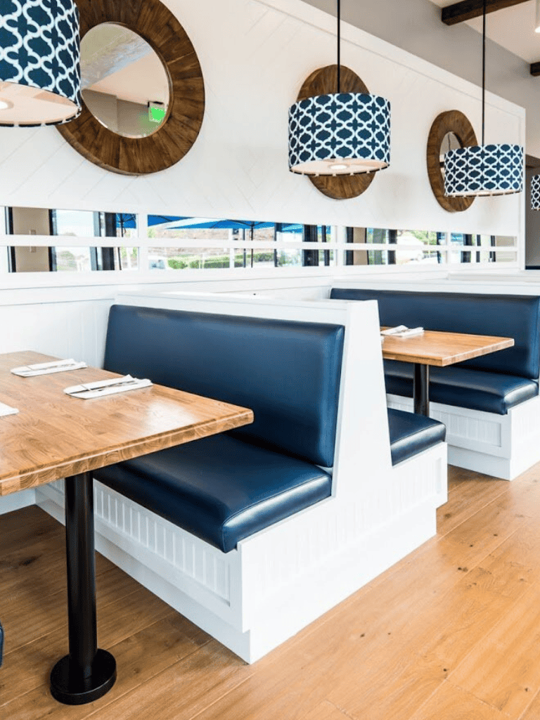 Cozy restaurant booth seating with navy blue cushions and stylish decor for a welcoming dining experience.