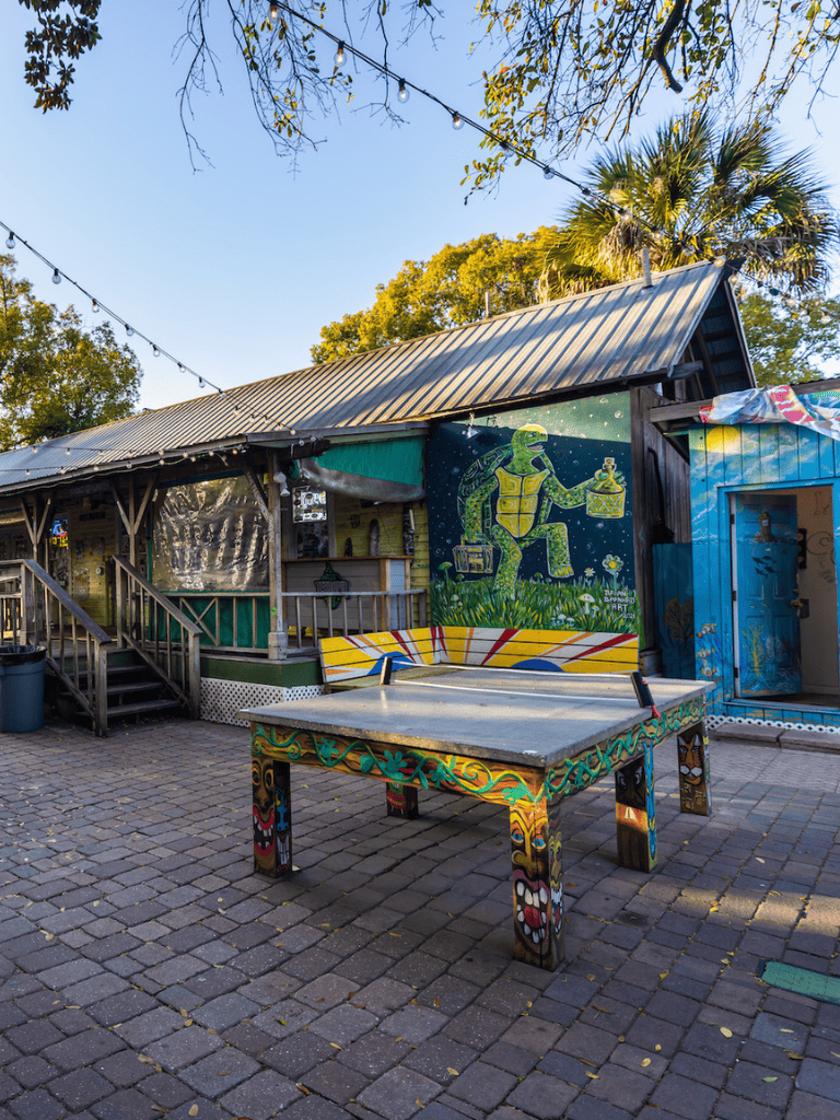 Colorful outdoor bar with mural art and ping pong table at Quest for Directions.