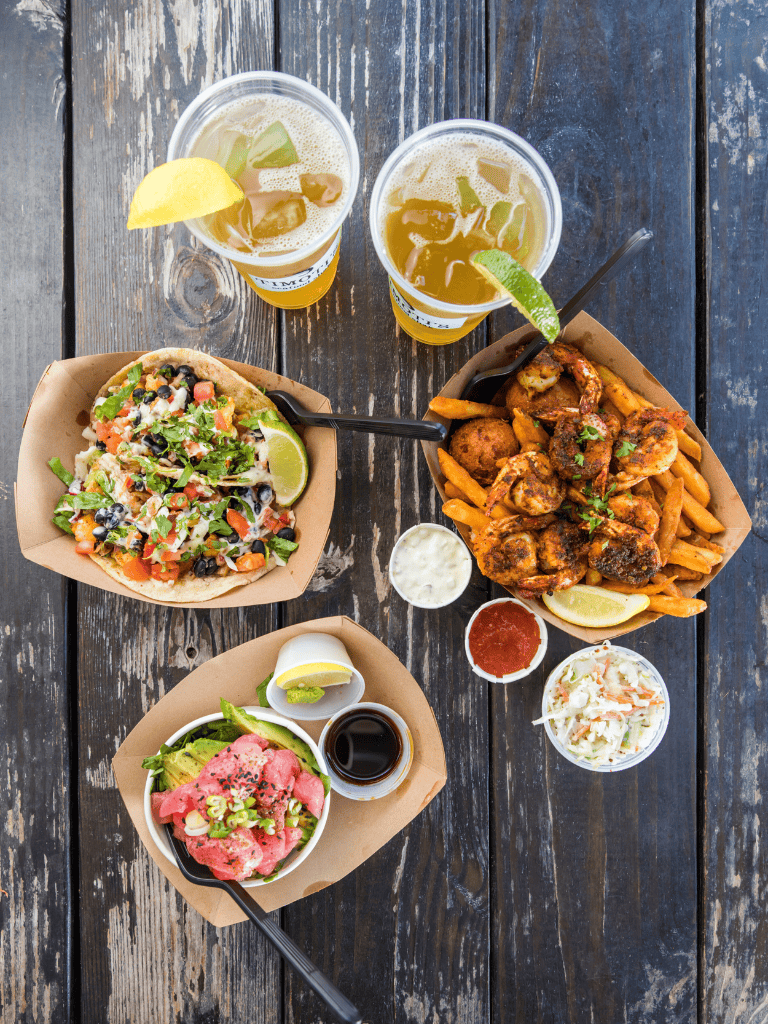 Juicy chicken wings, fresh salads, and cold drinks on rustic wooden table, Perfect for American cuisine dining.