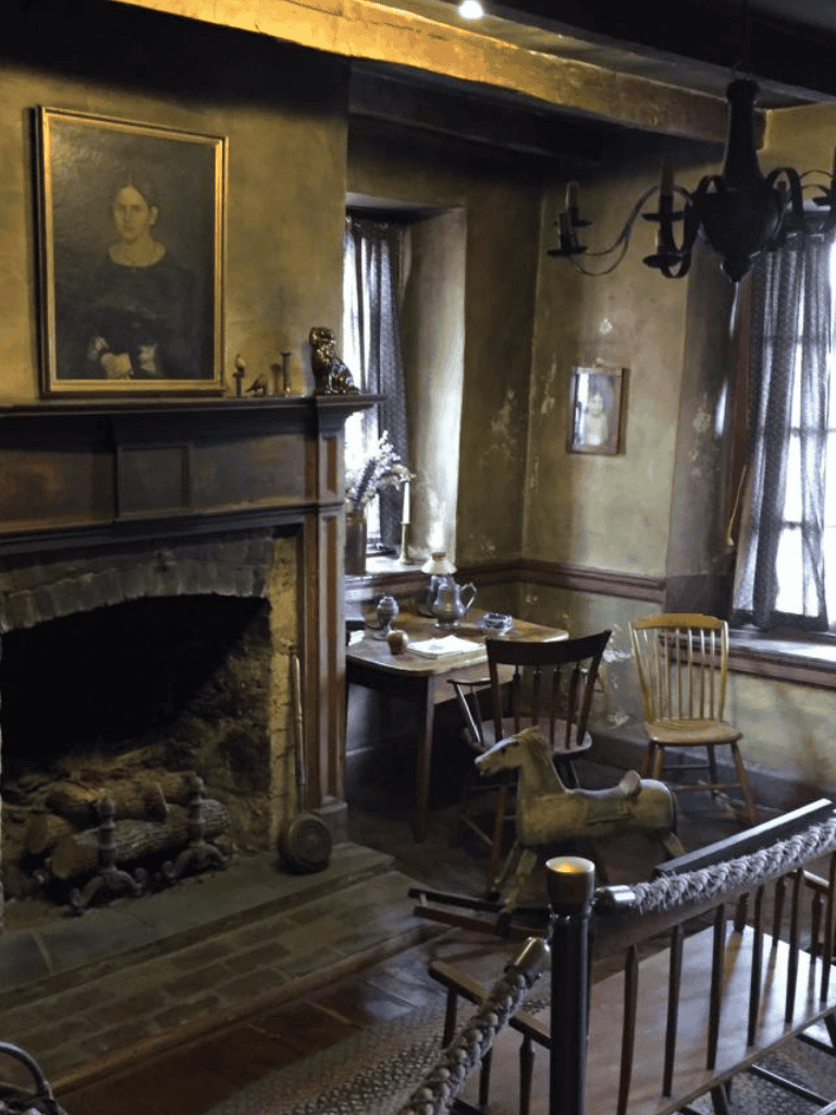 Antique living room with fireplace, vintage furniture, and rustic decor in historic home.
