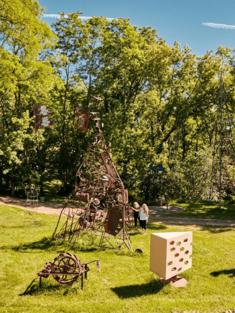 Iron sculpture art installation at QuestForDirections outdoor sculpture park in lush green park setting.