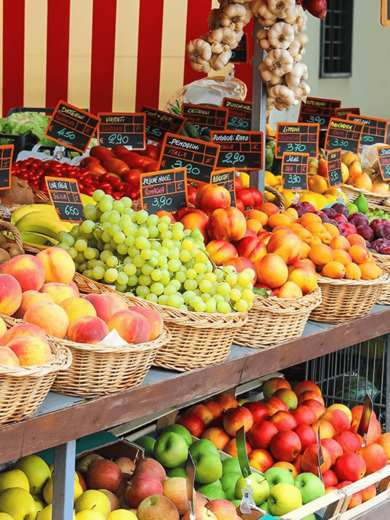 Fresh fruit market with colorful apples, grapes, and peaches for sale.