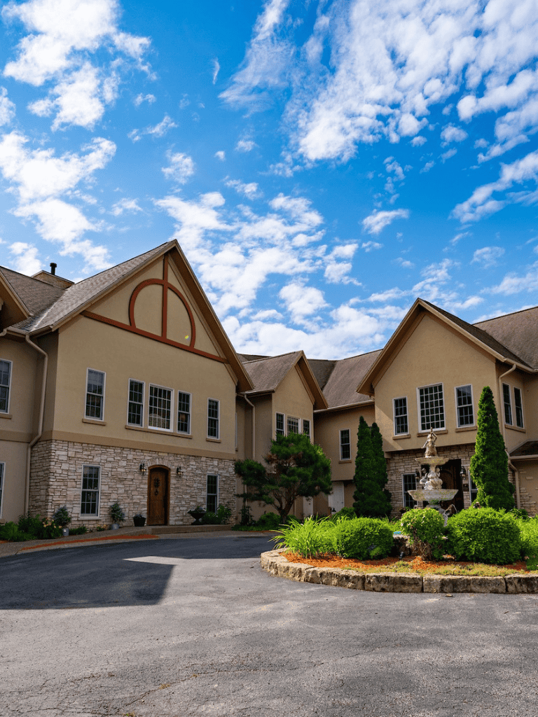 Luxurious residential building with manicured garden, sunny sky, and modern architecture.