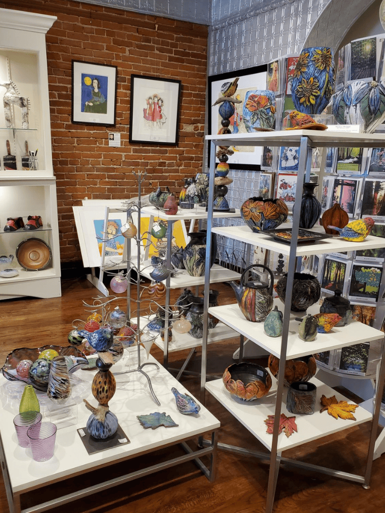 Colorful handcrafted glass art and pottery display at Quest For Directions art shop.