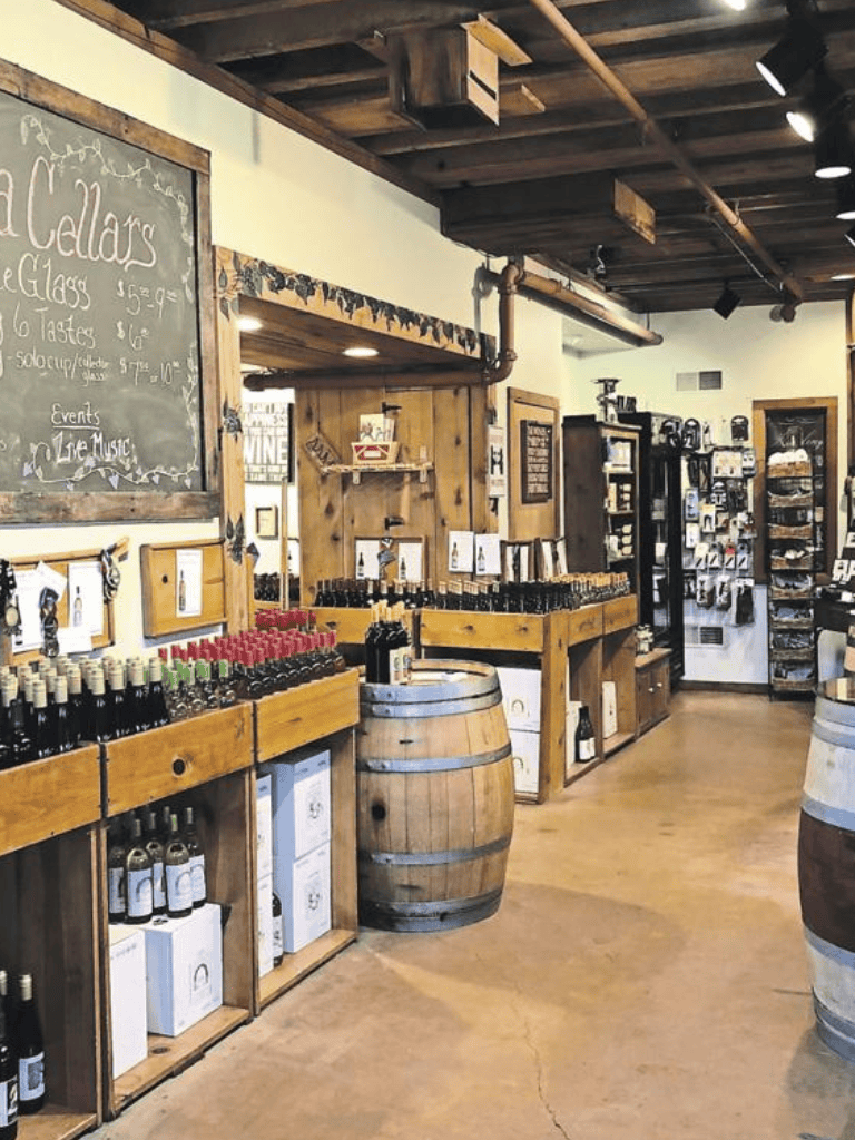 Handcrafted wine and craft beer shop with rustic decor, wine bottles, and bottles displayed on wood shelves.