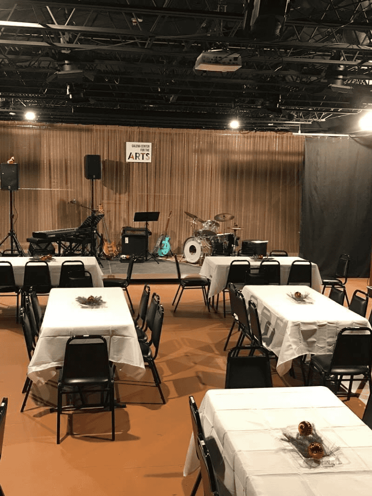 Comfortable event space with stage and musical instruments at QuestForDirections.