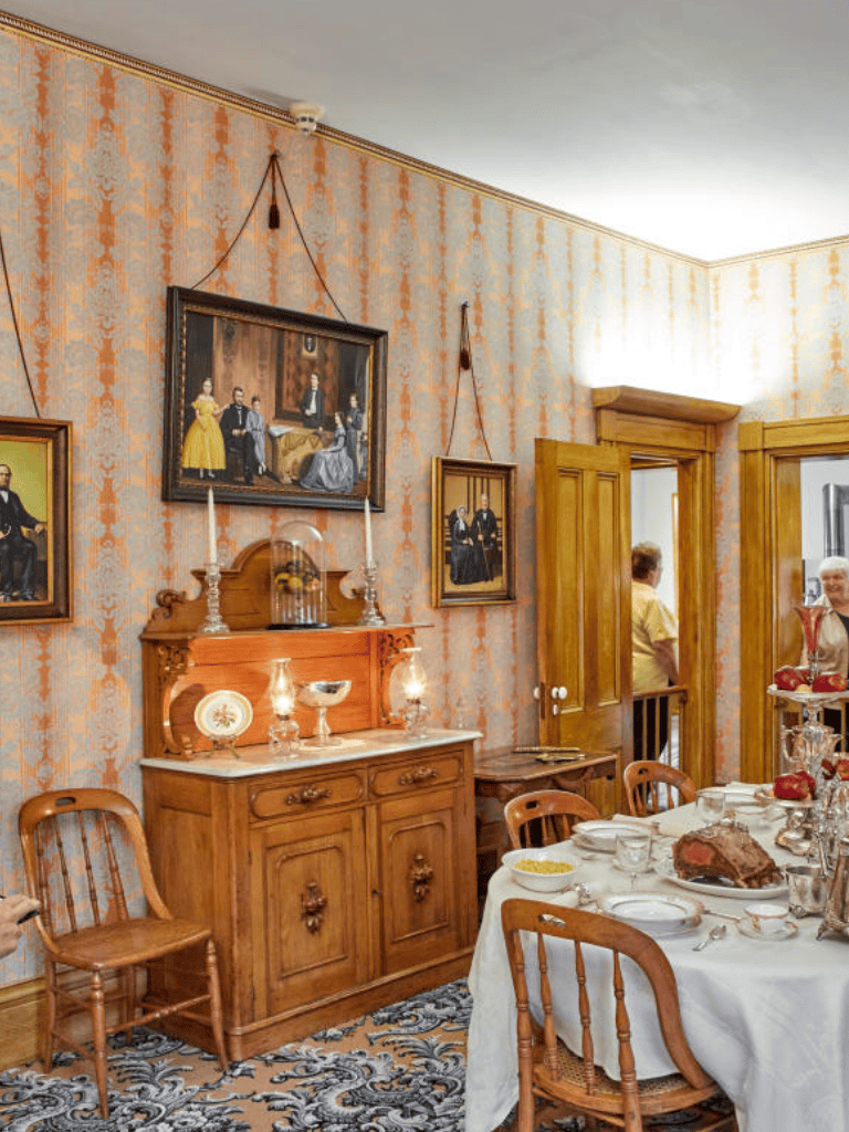 Elegant Victorian dining room with antique furniture and vintage artwork, capturing historical ambiance.