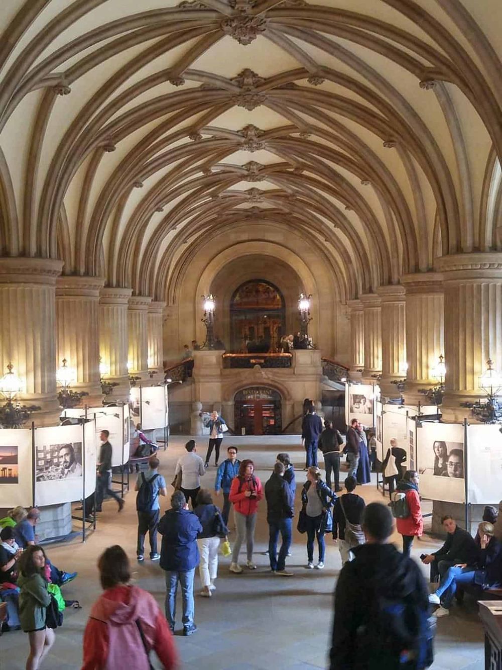 Elegant historic architecture interior at QuestForDirections exhibit space, showcasing grand vaulted ceilings and lively visitor engagement.