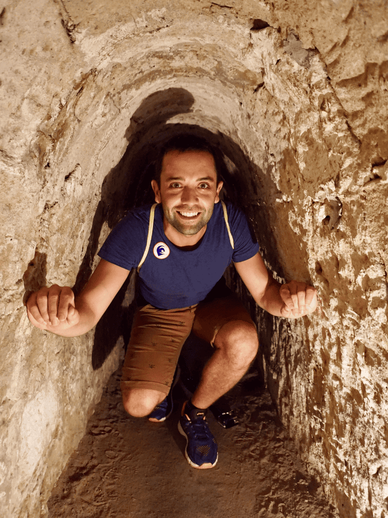 Excavation explorer crawling through ancient tunnel, uncovering historical secrets.