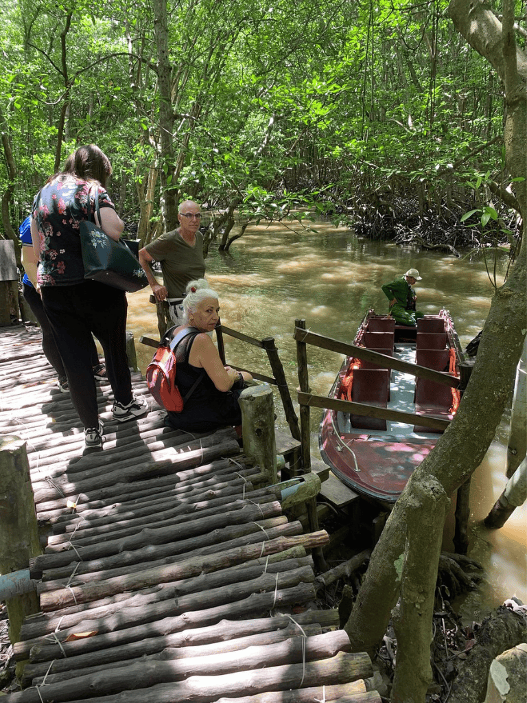 1. Small group of tourists at waterway docking area surrounded by lush greenery in a rainforest.
