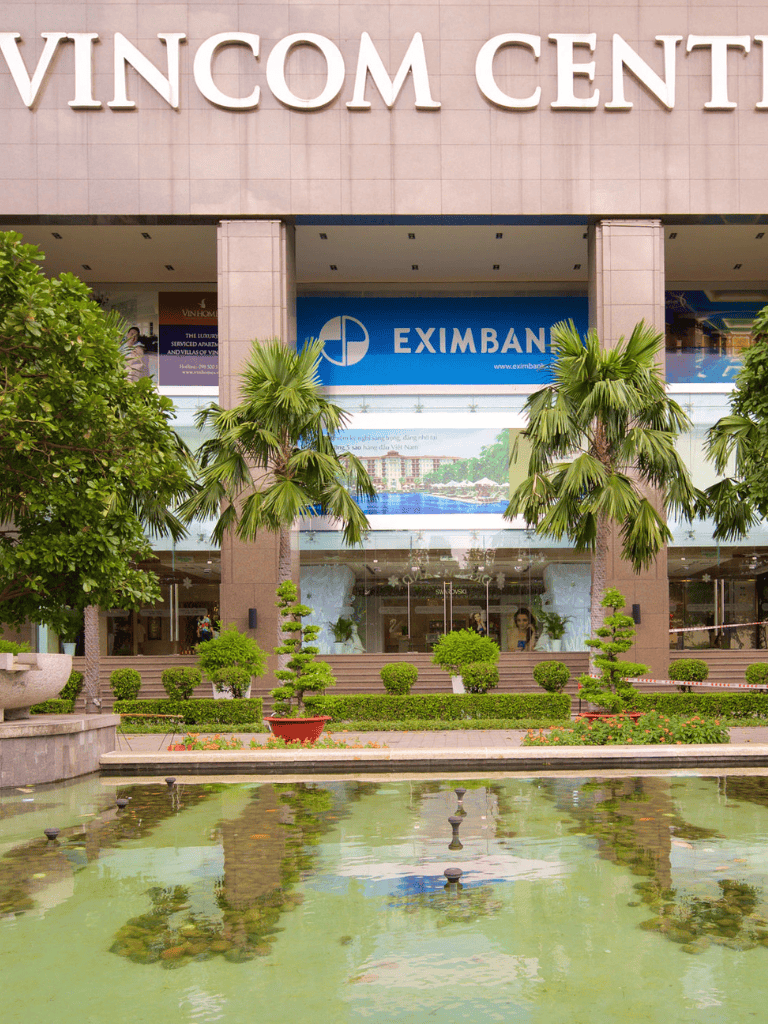 Modern commercial building with lush greenery and water fountain, available at QuestForDirections for location guidance.