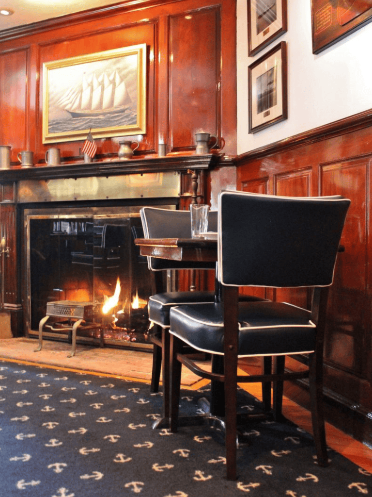 Cozy indoor dining area with a crackling fireplace and nautical-themed decor at QuestForDirections.