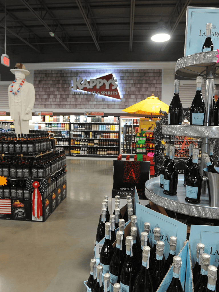 High-end wine bottles display at QuestForDirections liquor store in front of Kappy's signage.