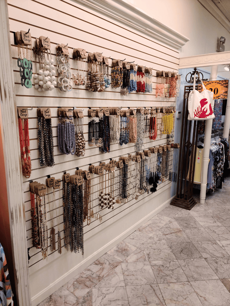 Colorful beaded jewelry display with necklaces and earrings in a boutique store.