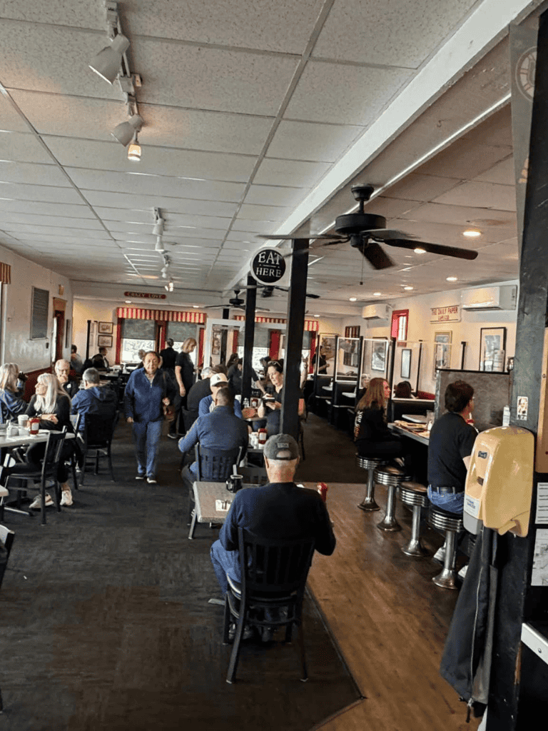 People dining inside a restaurant with a cozy atmosphere and a variety of seating options.