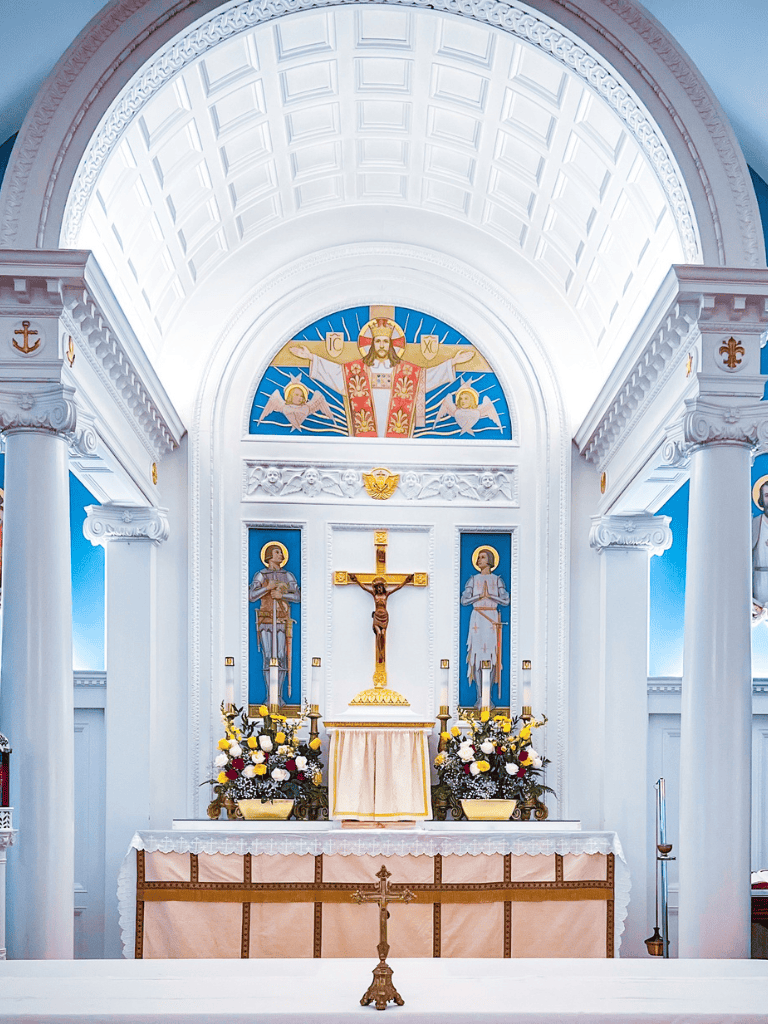 Ancient Catholic church altar with gold crucifix and religious icons, serene worship space.