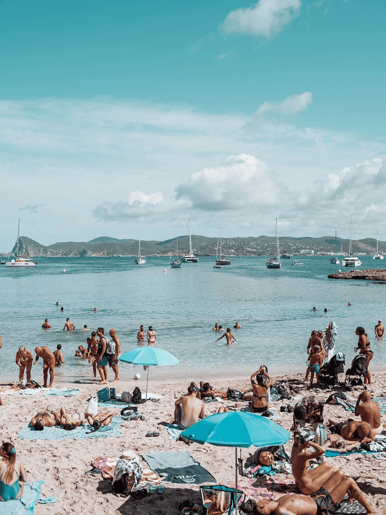 1. Beautiful beach with sailboats and sunbathers, perfect for travel and leisure.