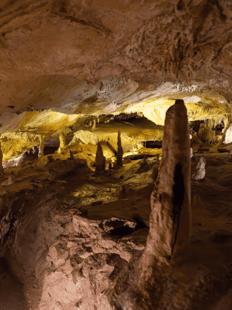 Mysterious cave formations with stalactites and stalagmites in underground景—adventure tourism.