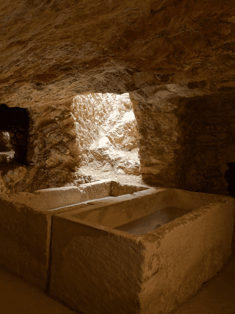 Ancient stone bathtubs inside a historic cave or underground chamber.
