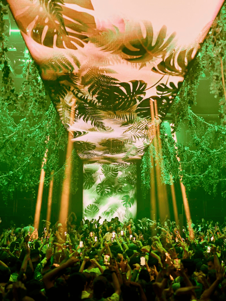 Lush tropical foliage and monstery ceiling decor create an exotic party environment at QuestForDirections event.